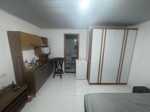 a room with a kitchen and a room with a bed at kitnet in Colombo +9 photos
