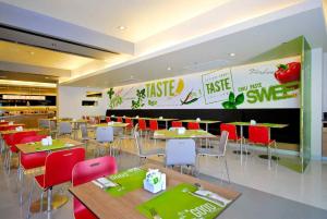 a restaurant with tables and chairs and a large sign at Ibis Bangkok Sukhumvit 4 in Bangkok