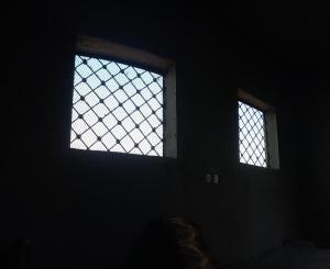 two windows in a dark room with a lattice window at فندق الابتسامة 