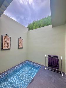 a room with a swimming pool with a towel and a chair at Diiza Glamping Tawangmangu in Tawangmangu