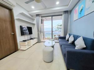 a living room with a blue couch and a tv at 天空逸寓 in Ho Chi Minh City