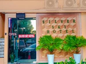 a store door with two palm trees in front of it at Silver Sky hotel in Kuala Lumpur
