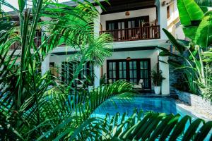 a house with a swimming pool and palm trees at The Secret Luang Prabang in Luang Prabang