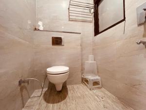 a bathroom with a white toilet in a room at WooibHotels The Divine Ganga Haridwar 