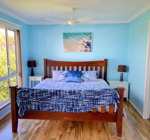 a bedroom with a bed with blue walls at Falcon Bay Family Retreat in Falcon