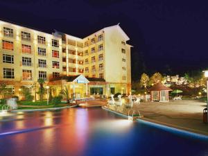 a hotel with a swimming pool in front of a building at Pullman Zhangjiajie Hotel - Instagrammable in Zhangjiajie