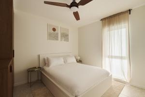 a bedroom with a white bed with a ceiling fan at Maisonn Hinoki Spacious Holiday Oasis in Daleys Point +34 photos