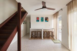 a living room with a dining room table and a ceiling fan at Maisonn Hinoki Spacious Holiday Oasis in Daleys Point