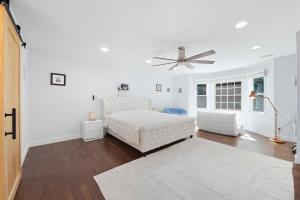 a white bedroom with a bed and a ceiling fan at Bedrooms with Private Bath - 12min from Uptown in Charlotte