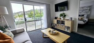 a living room with a couch and a table in front of a window at Stay n Play n Russell in Russell