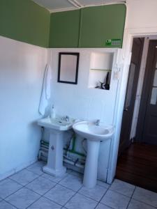 バルパライソにあるHostal Mirador Valparaísoの白い洗面台とトイレのあるバスルーム +38枚の写真