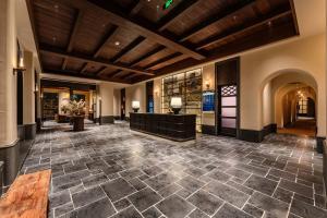 an empty lobby with a large stone floor and wooden ceilings at The Woven Inn in Shunde