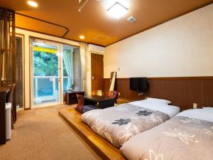 ein Schlafzimmer mit zwei Betten und einem Schreibtisch und einem Fenster in der Unterkunft Hotel Casual Euro in Nikko + 39 Fotos