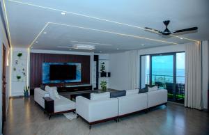 a living room with white couches and a flat screen tv at Semo's Aqua luxury 6 bedrooms Penthouse sea views in Mombasa
