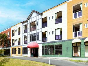 een appartementengebouw met een groene en gele gevel bij Hotel Casual Euro in Nikko