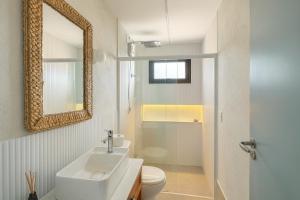 a bathroom with a sink and a toilet and a mirror at Apartamento no Falesias de Pipa - Veleiros 212 in Pipa +20 photos