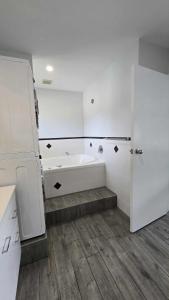 a white bathroom with a tub and a shower at Stay n Play n Russell in Russell