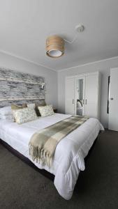 a bedroom with a large bed with a wooden headboard at Stay n Play n Russell in Russell +26 photos
