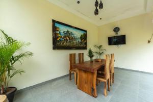 Un comedor con mesa y sillas de madera. en Sinden Villa, en Payangan