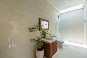 Un baño con lavabo, inodoro y espejo. en Sinden Villa, en Payangan 13 fotos más