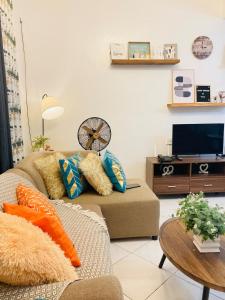 a living room with a couch and a tv at Bahay-Kapehan sa Villa in Tambo