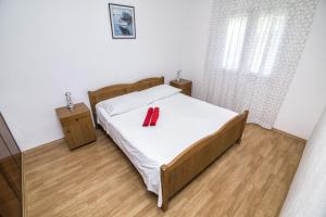 a bedroom with a bed with a red object on it at Apartament Skoko in Slatine