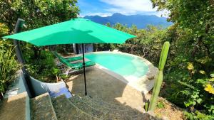 a green umbrella sitting next to a swimming pool at Utopia Casas Boutique in Oaxaca City