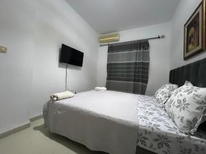 a small bedroom with a bed and a television at Dar Saïda Guest house in Tunis