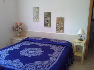 a bedroom with a blue bed and two night stands at Agriturismo La Magione Del Capitano in Montecorvino Pugliano +2 photos