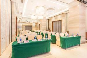 a conference room with green tables and chairs at Guangdong Workers Santorium-Sea Side Park K Building Hotel in Huidong
