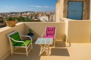 a pair of chairs and a table on a balcony at Dar Saïda Guest house in Tunis