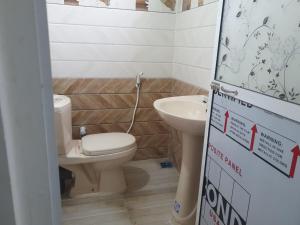 a bathroom with a toilet and a sink at Nishadi Holiday Inn Kataragama in Kataragama +17 photos