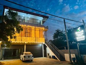a building with a car parked in front of it at Nishadi Holiday Inn Kataragama in Kataragama