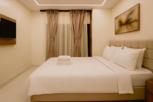 a bedroom with a large white bed with a window at 3 Raahi Varanasi in Varanasi