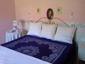 a bedroom with a bed with white pillows and a picture on the wall at Agriturismo La Magione Del Capitano in Montecorvino Pugliano