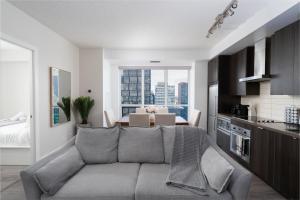 un salon avec un canapé et une table dans l'établissement 3BR Skyline Condo - By CN Tower & MTCC & Free Parking, à Toronto