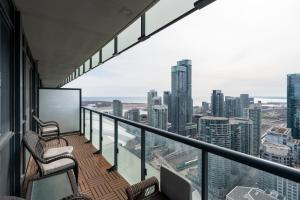 un balcon avec des chaises et une vue sur une ville dans l'établissement 3BR Skyline Condo - By CN Tower & MTCC & Free Parking, à Toronto