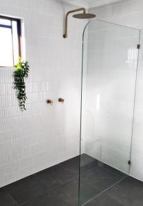 a shower with a glass door in a bathroom at Wurtulla Guesthouse, Modern & Tranquil in Kawana Waters
