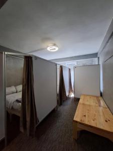 Cette chambre comprend un lit et une table en bois. dans l'établissement Nonoteru Chiang Mai , KamPhaengDin, à Chiang Mai 17 autres photos