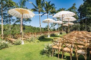 an aisle with chairs and umbrellas at a wedding at Padma Resort Ubud in Payangan