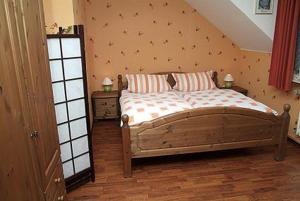ein Schlafzimmer mit einem Holzbett mit zwei Kissen in der Unterkunft Hotel Stoffels in Schmallenberg