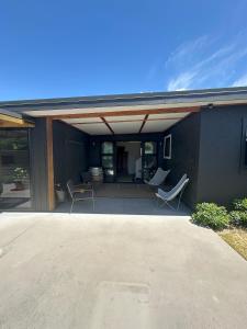 a patio with two chairs and a table at Lovely Wanaka Crib in Wanaka