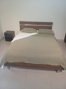 een slaapkamer met een groot bed met een houten hoofdeinde bij Experience beachfront tranquility at Vuda in Lautoka