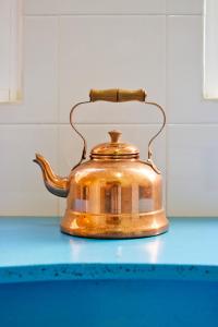 a golden tea kettle sitting on a blue counter top at Porto Sé Apartamentos in Porto