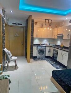 a kitchen with white appliances and a table and a chair at Beach Appartement & Résidence Luxury Aourir in Agadir +3 photos