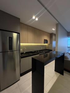 eine Küche mit einem Kühlschrank aus Edelstahl und einer schwarzen Arbeitsplatte in der Unterkunft Espetacular Athenas Future in Belém