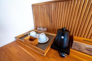 a wooden box with a tea pot and glasses on it at KAPI Sebatu Villa in Tampaksiring