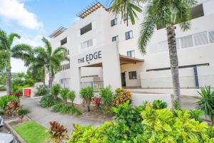 a building with palm trees in front of it at Azure at The Edge, Steps to the Esplanade in Cairns North
