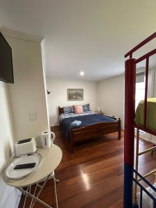 King River Caravan Park في Whitfield: غرفة نوم مع سرير وطاولة مع مكتب