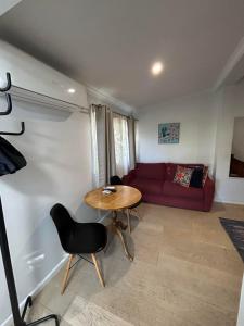 a living room with a table and a red couch at King River Caravan Park in Whitfield